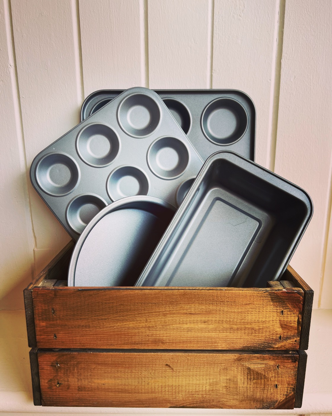 Baking tins in a wooden crate